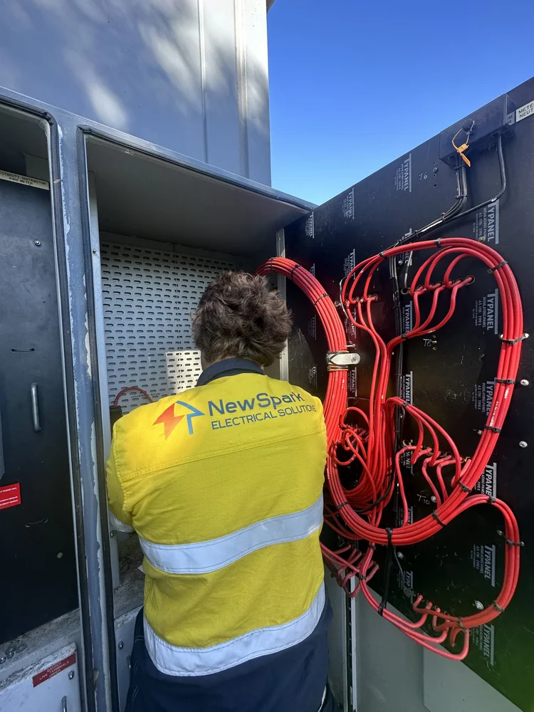 NewSpark electrician working inside an electrical cabinet