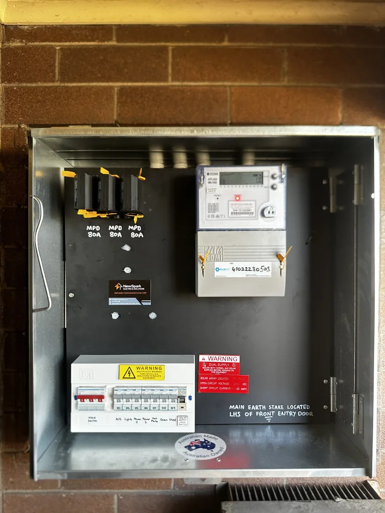 Electrical meter box with circuit breakers, warning labels and digital meter