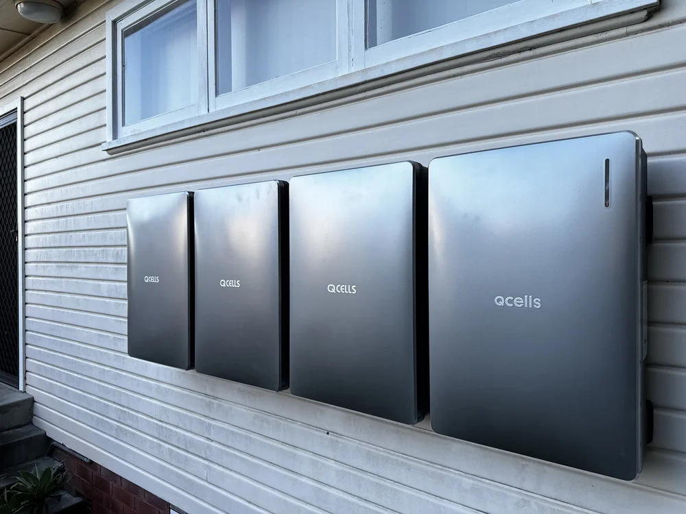 Four solar inverter boxes mounted on an exterior wall