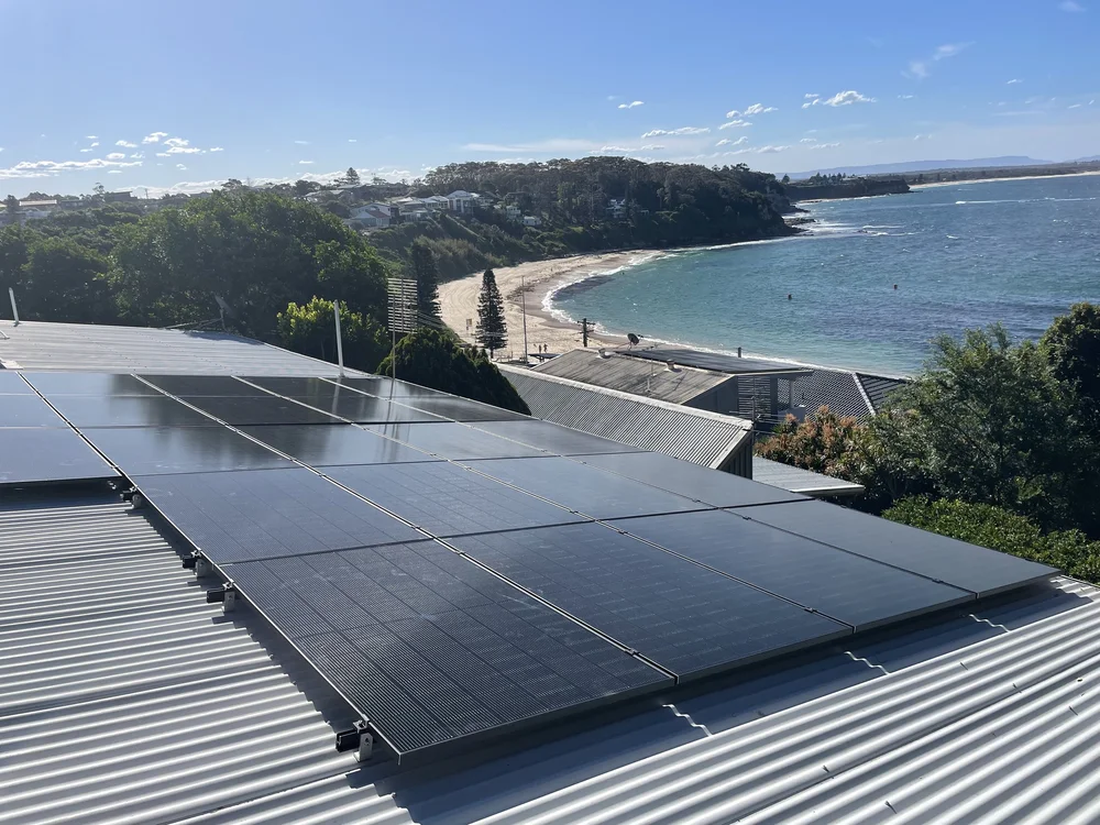 Solar panels installed on a rooftop overlooking the bay