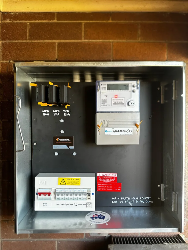 Electrical meter box with circuit breakers, warning labels and a digital meter